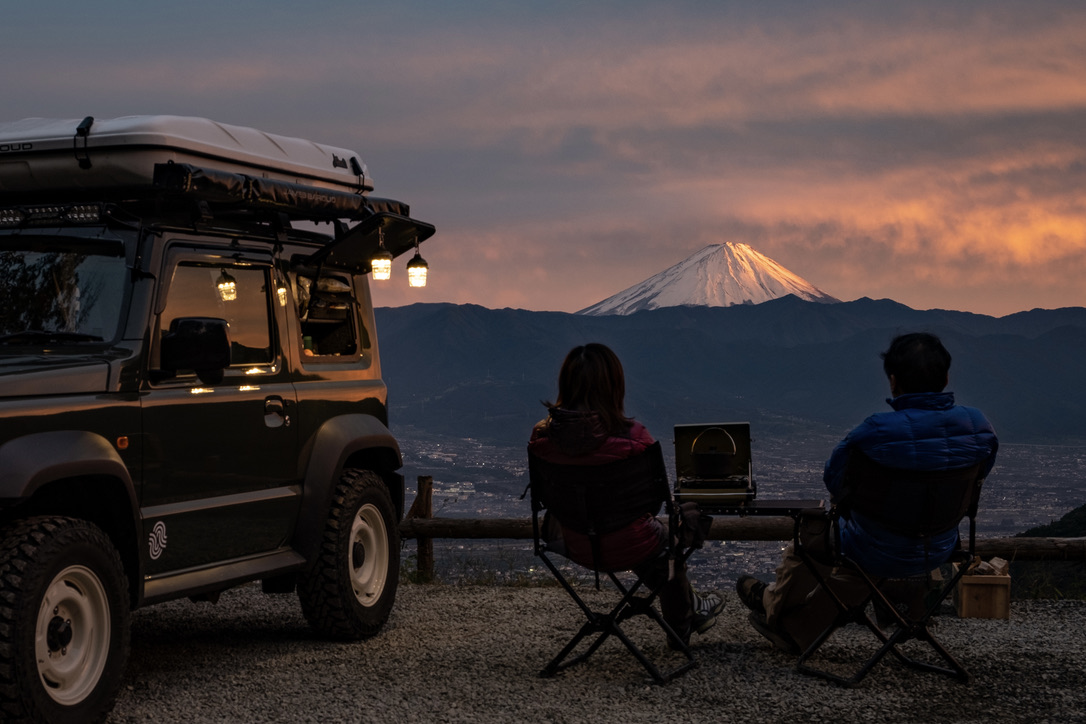 Two people sitting looking at pink Mt Fuji