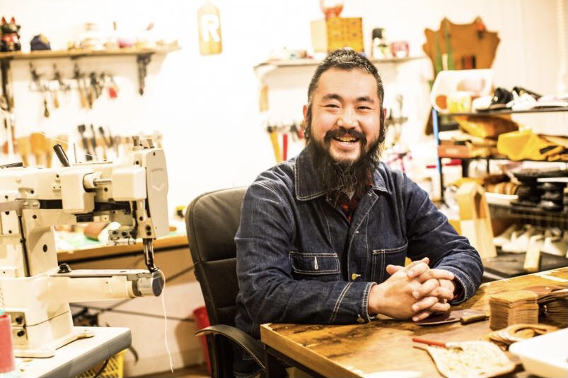smiling asian man with beard in workshop