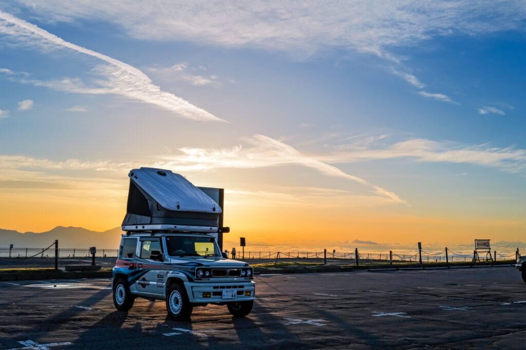 雲海の上の日の出と、ルーフテントを広げたJimnyのキャンピングカー