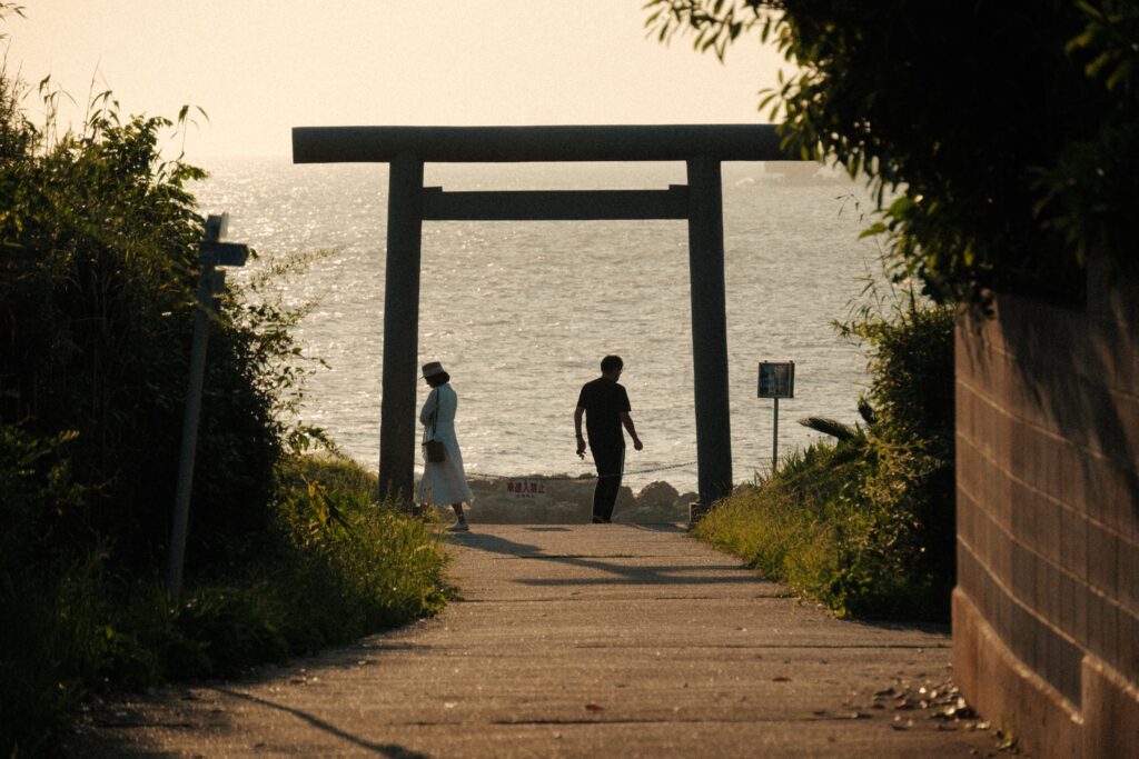 千葉の海岸にある鳥居へ歩いていく2人