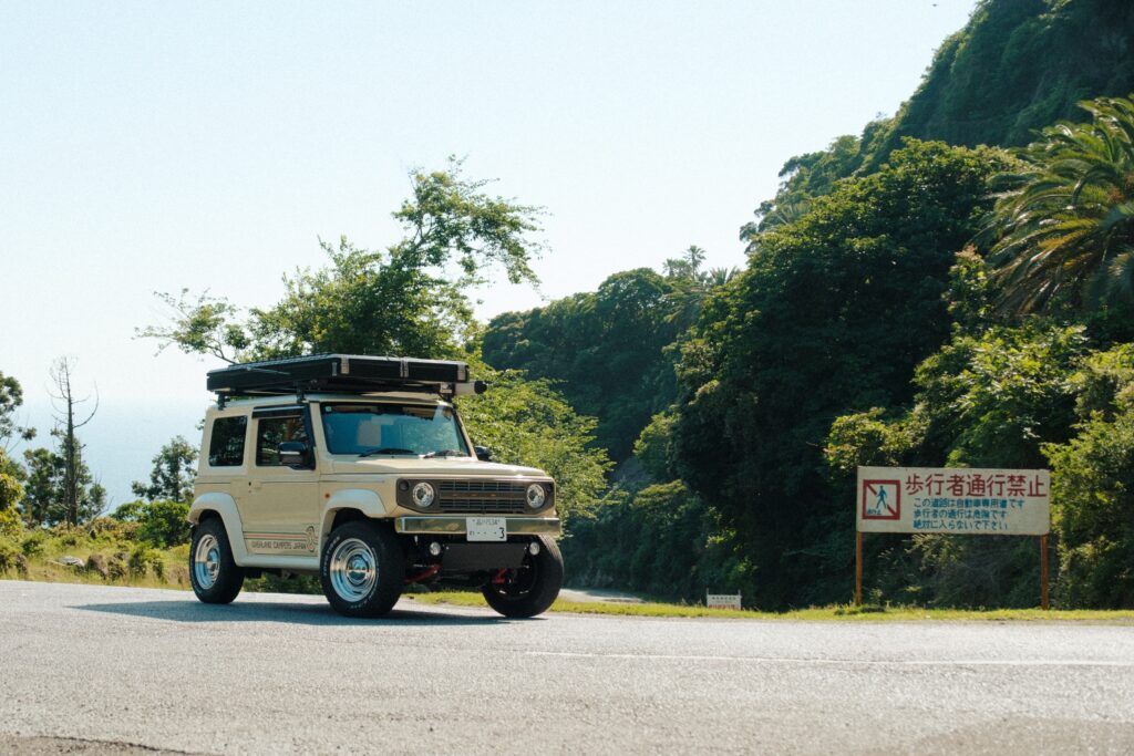 A Suzuki Jimny camper on a quiet coastal road in Chiba