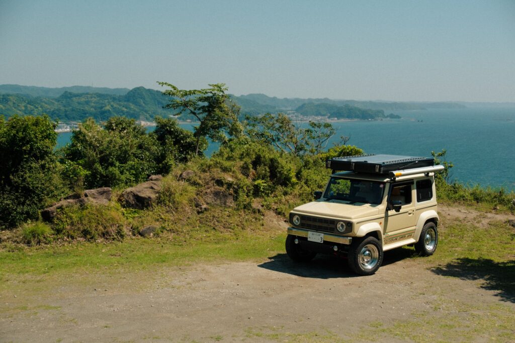 海を見下ろす草地の岬に停まるJimnyのキャンピングカー