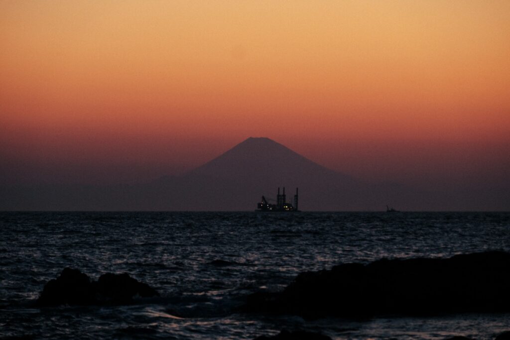 Mt Fuji in silhouette across the sea at dusk, from the Chiba coast